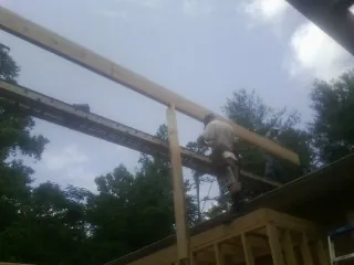 Carpenter setting a ridge beam over a new addition frame — Ice Dam Removal by Roofing Brothers in Chestertown