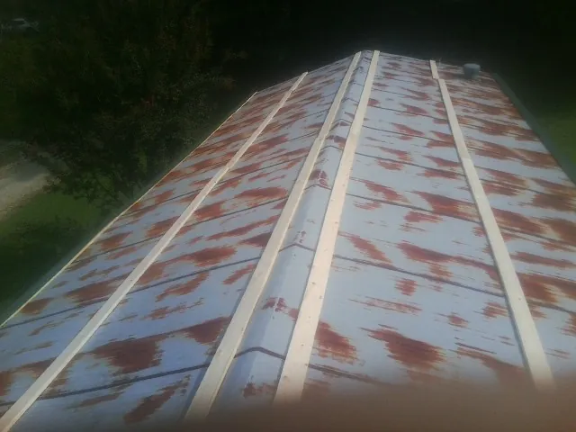 Rusted metal roof panels with new wood purlins before replacement — Storm Damage Roof Repair in Chestertown by Roofing Brothers