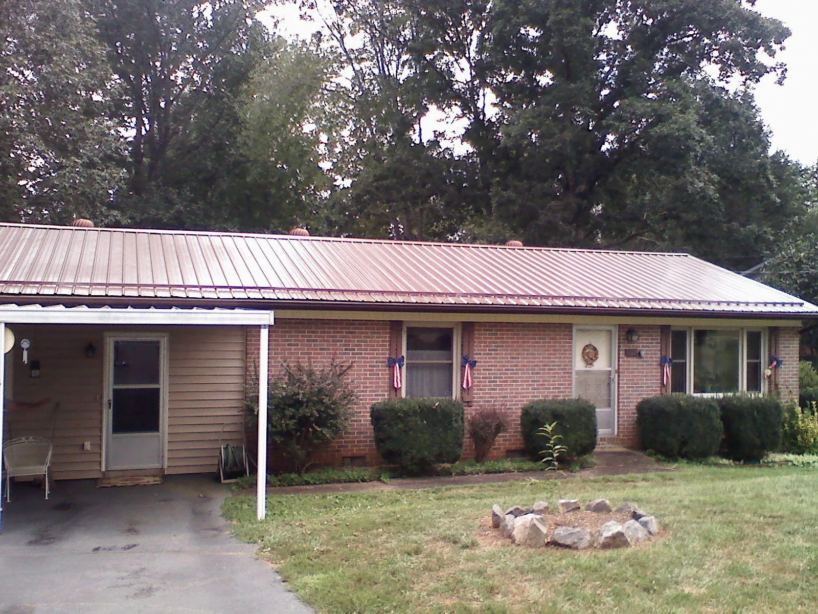 Bronze metal roof and carport on a brick ranch home — Roof Repair work by our crew in Chestertown